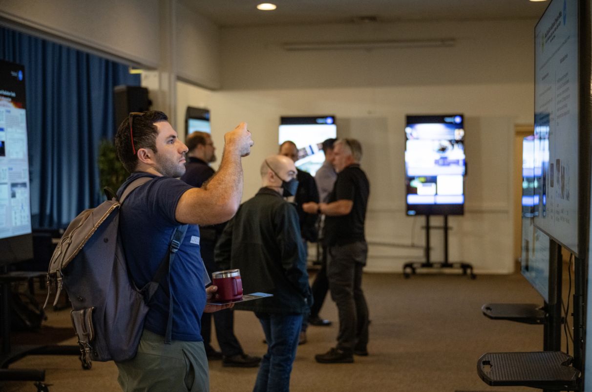 Attendees of the 2024 NASA SmallSat Learning from Experience, Achievements, and Resolution, Navigation LEARN forum read about other projects during the poster session in the ballroom of Building 3 at NASA Research Park.